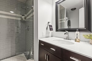 The shared bathroom with a single sink vanity and walkin shower.