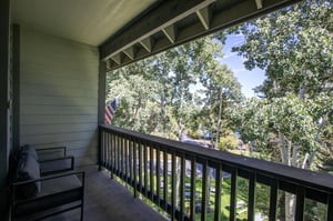 The private deck overlooks a grove of trees.