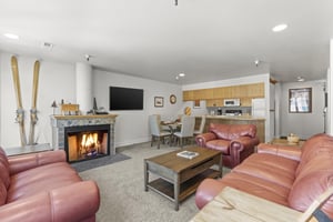 The living room with comfy red leather furniture and cozy fireplace.
