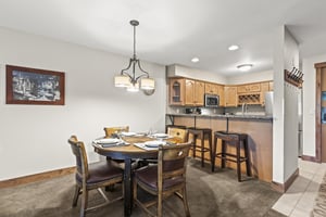The kitchen table with seating for 4 guests and the breakfast bar with seating for 3 guests.