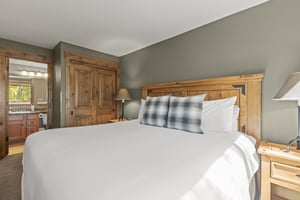 The main suite has a kingsize bed and wood furniture.