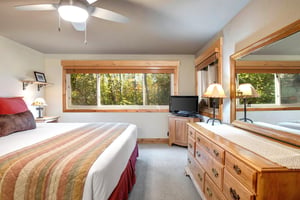 The en suite bedroom with a king size bed and wooden furniture.