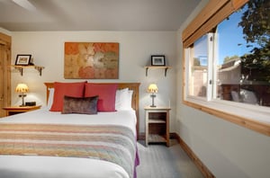 The king size bed with red accent pillows and art on the wall tying them in.