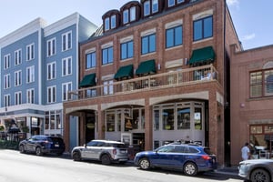 Fashion Coalition building, brick with green awnings located on Historic Main Street