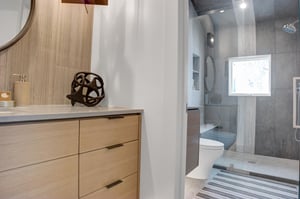 Separate vanities in the guest bathroom with glass panel walkin shower enclosure.