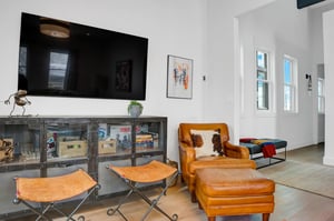 Leather accent chair in the apres room with sliding barn style door for added privacy.