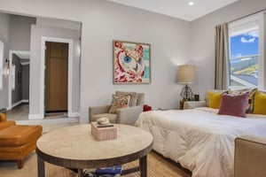 Sleeper sofa made into a queen sized bed with crisp white linens and colorful decor in the apres room.