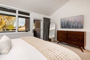The second main suite with a kingsize bed and a glass door leading to a private deck.