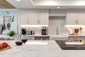The bright kitchen is well equipped with many appliances, utensils, and knives.