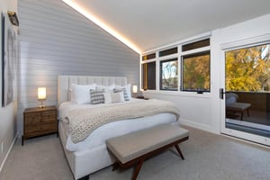 The second main suite with a kingsize bed and a glass door leading to a private deck.