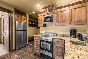 Step into your own rustic mountain retreat kitchen, where warm wood cabinets and granite countertops create the perfect space for cooking.