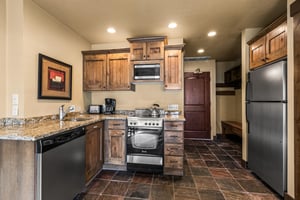 The efficient kitchen with oven, refrigerator, microwave, and dishwasher.