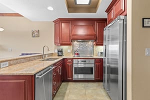 Your fully equipped gourmet kitchen features rich cherry cabinetry, granite countertops, and stainless steel appliances.