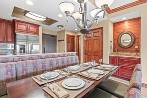 Your elegant dining area features rich wood cabinetry, modern appliances, and a beautifully set table for memorable meals.