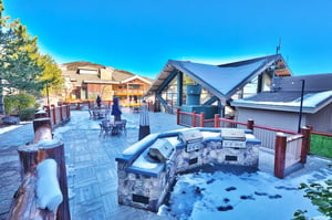 Shared outdoor patio space with chrome gas grills, seating areas, heat lamps