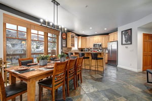 Spacious openconcept kitchen and dining area with warm wood cabinetry, modern appliances, and a welcoming breakfast bar.