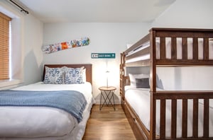 Sleep comfortably in this bright bedroom featuring both a queen bed and bunk beds.