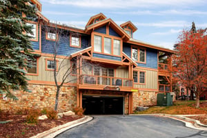 Beautiful multilevel mountain property featuring stone and timber architecture with covered parking.