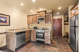 The efficient kitchen with oven, refrigerator, microwave, and dishwasher.