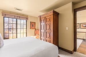 The main suite bedroom with a king size bed and large sliding glass door leading to a private patio.