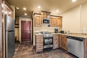 Your fully equipped kitchen awaits with warm wood cabinets, granite countertops, and stainless steel appliances.