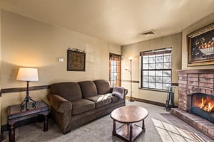 The living room with a leather sofa and a chair in the corner.