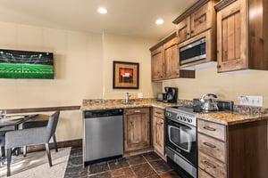 The efficient kitchen with oven, refrigerator, microwave, and dishwasher.