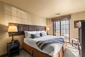 The main suite bedroom with a king size bed and large sliding glass door leading to a private patio.