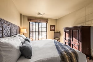 The main suite bedroom with a king size bed and large sliding glass door leading to a private patio.