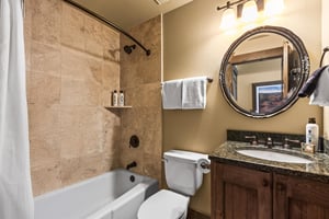 The guest bathroom with a bathtub and shower combination.