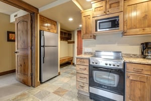 Step into your mountain retreat kitchen where rustic wood cabinets and granite counters create the perfect space.