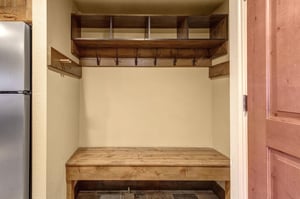 Your private mudroom awaits with custom wooden storage cubbies and hooks to keep your gear organized.