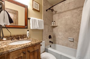 The en suite bathroom has a bathtub and shower combination.