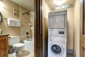 Your bathroom features a relaxing tubshower combo with warm stone tiles, while the convenient inunit washer and dryer keeps your clothes fresh throughout your stay.