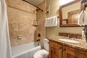 Step into your elegant marble bathroom with warm stone tiles and granite countertops .