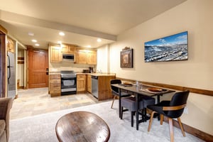 Your cozy openconcept space combines a fully equipped kitchen with warm wood cabinets and a stylish dining area.