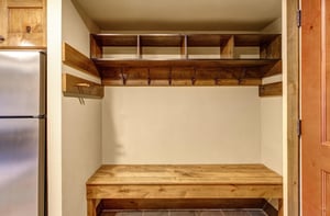 Your private mudroom awaits with custom wooden storage cubbies and hooks to keep your gear organized.
