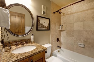Step into your elegant marble bathroom with warm stone tiles and granite countertops .