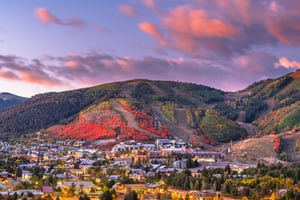 Park City at dusk with the red fall colors lighting up the hillside at Park City Mountain Resort.