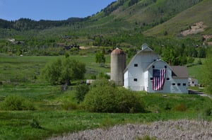 Historic McPolin barn in the summer with a huge American flag on the front.