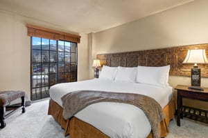 Sink into crisp white linens and enjoy the elegant carved headboard in your comfortable bedroom, featuring mountain views.