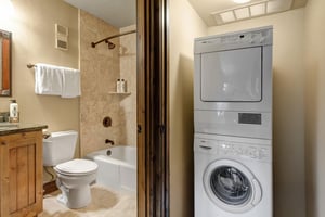Your bathroom features a relaxing tubshower combo with warm stone tiles, while the convenient inunit washer and dryer keeps your clothes fresh throughout your stay.