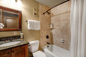 The en suite bathroom has a bathtub and shower combination.
