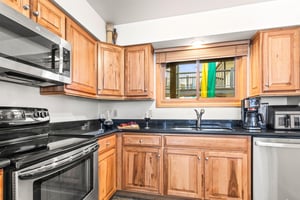 Your fully equipped kitchen features beautiful wood cabinetry, granite countertops, and modern stainless steel appliances.