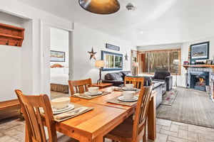 Relax in your openconcept living and dining space, where warm wood furnishings and a cozy fireplace create the perfect atmosphere.
