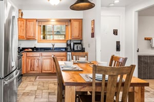 Your fully equipped kitchen features warm wood cabinets, modern appliances, and a charming dining table.