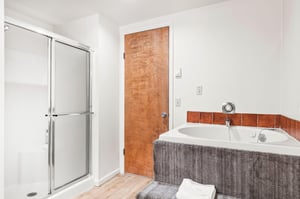 Unwind in your private spalike bathroom featuring a luxurious jetted tub and separate glass shower.