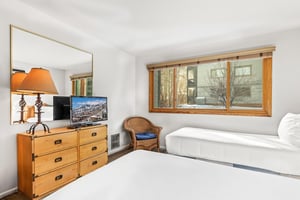 Relax in your comfortable bedroom with twin beds, entertainment center, and mountain views.
