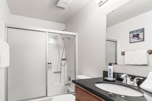 Refresh in your private bathroom featuring a modern showertub combo, granite vanity, and complimentary amenities.
