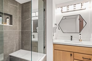 Step into your luxurious glassenclosed shower featuring elegant textured tile walls.